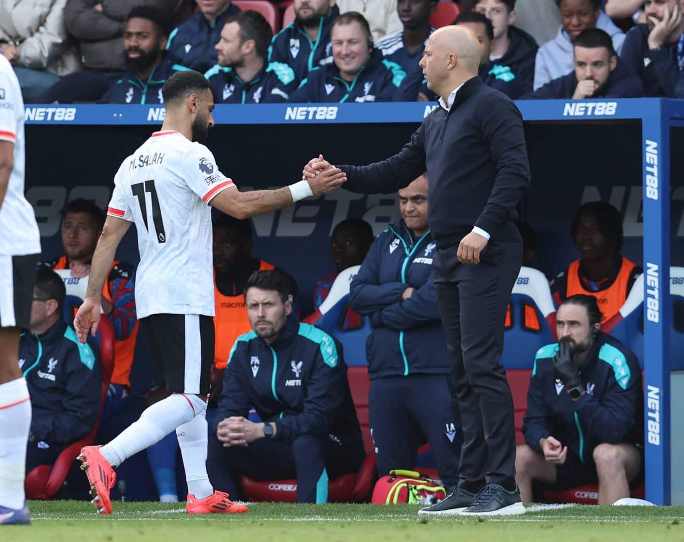 Slot e Salah se cumprimentam durante jogo do Liverpool