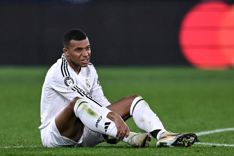 Mbapp&eacute; sentado no gramado ap&oacute;s sentir les&atilde;o