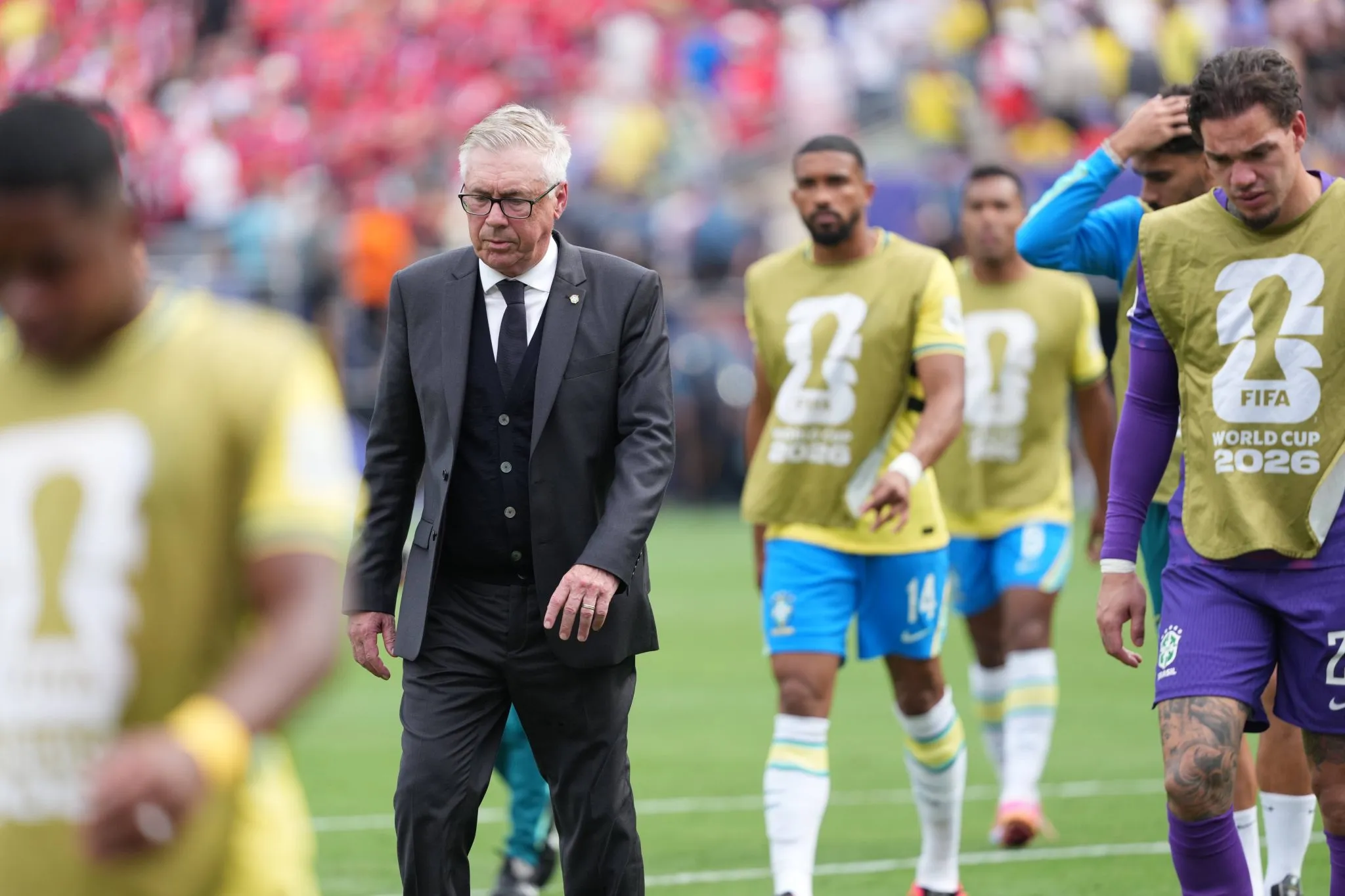 Carlo Ancelotti e jogadores da sele&ccedil;&atilde;o brasileira deixando o campo nas oitavas de final da Copa
