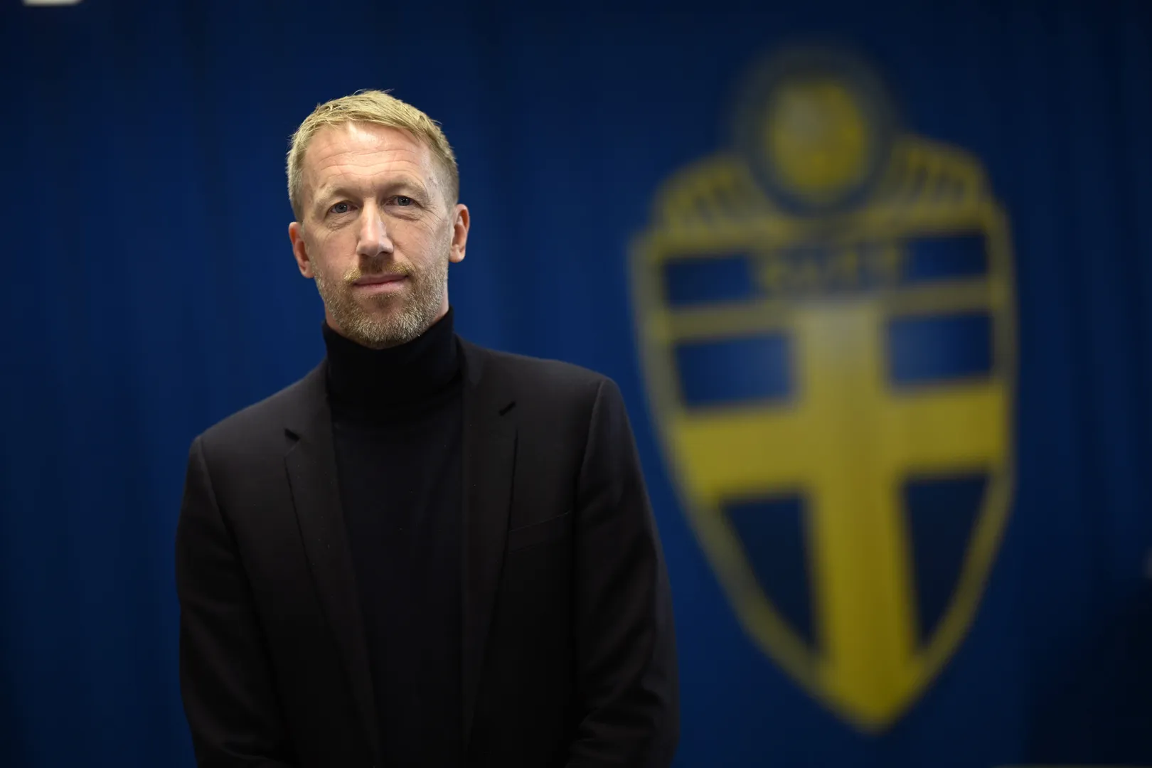 Graham Potter com o escudo da sele&ccedil;&atilde;o sueca ao fundo
