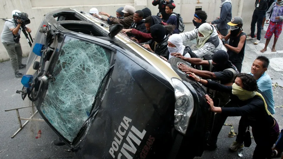 Protestos contra a Copa do Mundo viram carro da Pol&iacute;cia Civil (Foto: AP)