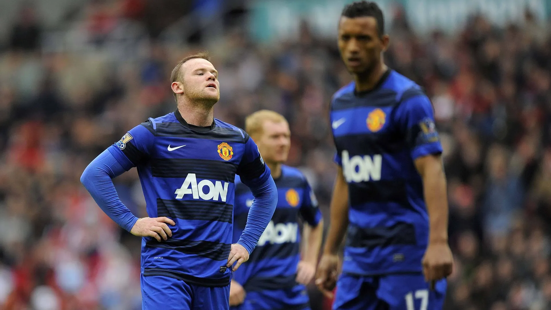 Wayne Rooney, Paul Scholes e Nani, jogadores do Manchester United, consternados ap&oacute;s saberem que o Manchester City havia conquistado o t&iacute;tulo da Premier League, no Stadium of Light, em Sunderland, em 13 de maio de 2012.