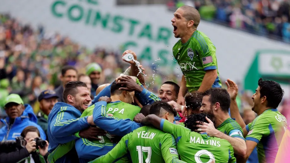 Seattle Sounders' Marco Pappa, second from left, is doused with water as he is mobbed by teammates, including Osvaldo Alonso, upper center, after Pappa scored his second goal of an MLS soccer match against the Los Angeles Galaxy, Saturday, Oct. 25, 2014, in Seattle. The Sounders beat the Galaxy, 2-0. (AP Photo/Ted S. Warren)