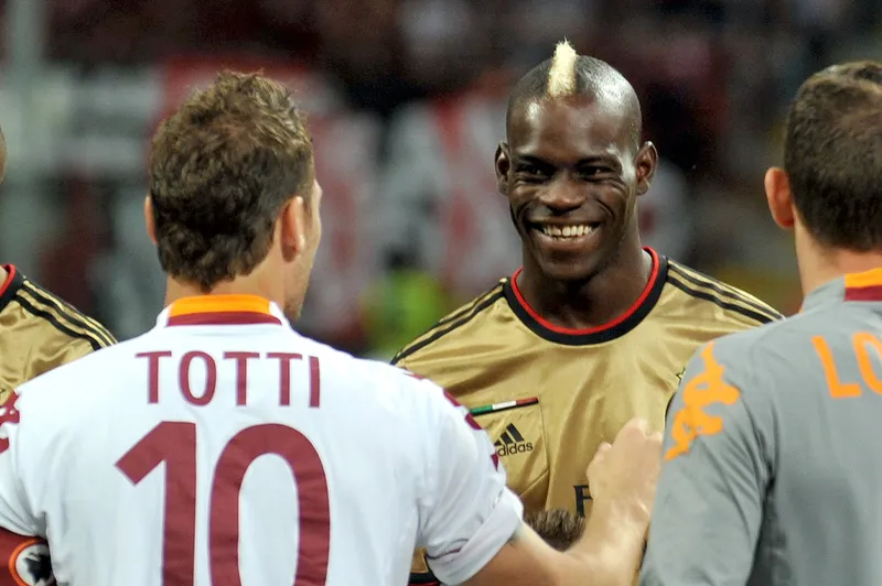 Totti e Balotelli se cumprimentam antes de um Milan x Roma, em 2013