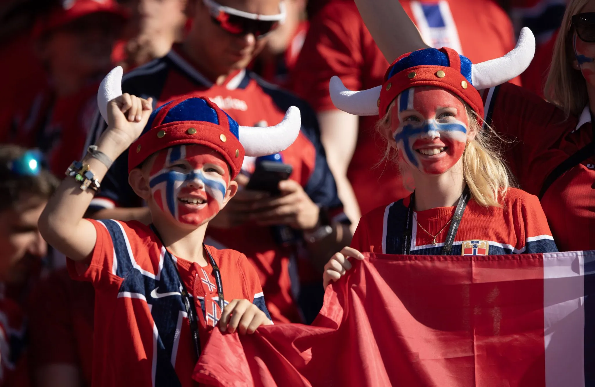 Jovens torcedores da Noruega com os rostos pintados durante jogo contra o Iraque