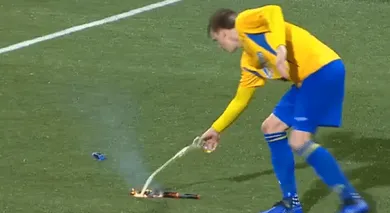No meio do jogo pela Copa da Holanda, o atacante apagou um sinalizador com um copo de cerveja