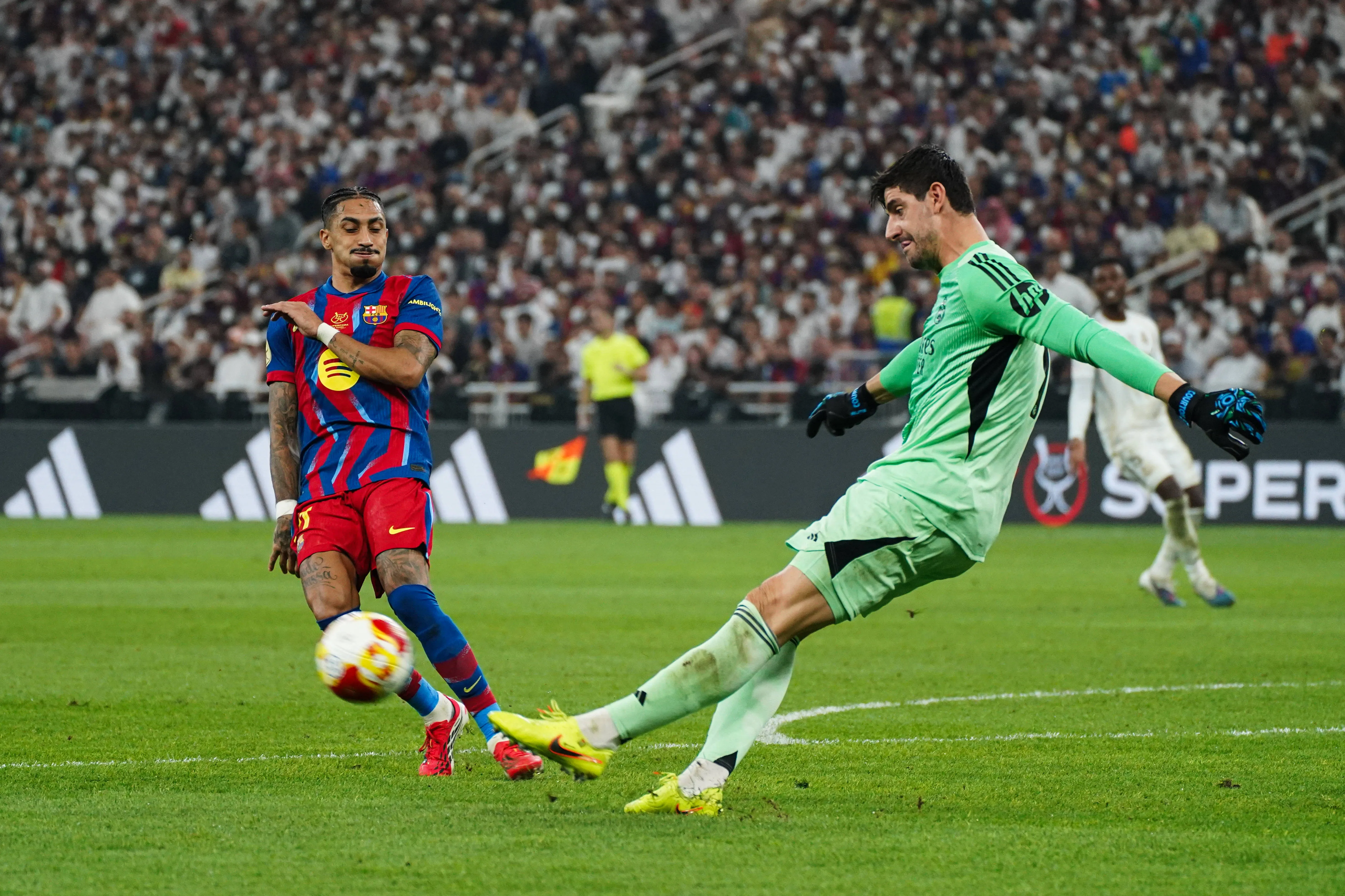 Raphinha e Courtois em a&ccedil;&atilde;o durante cl&aacute;ssico entre Barcelona e Real Madrid