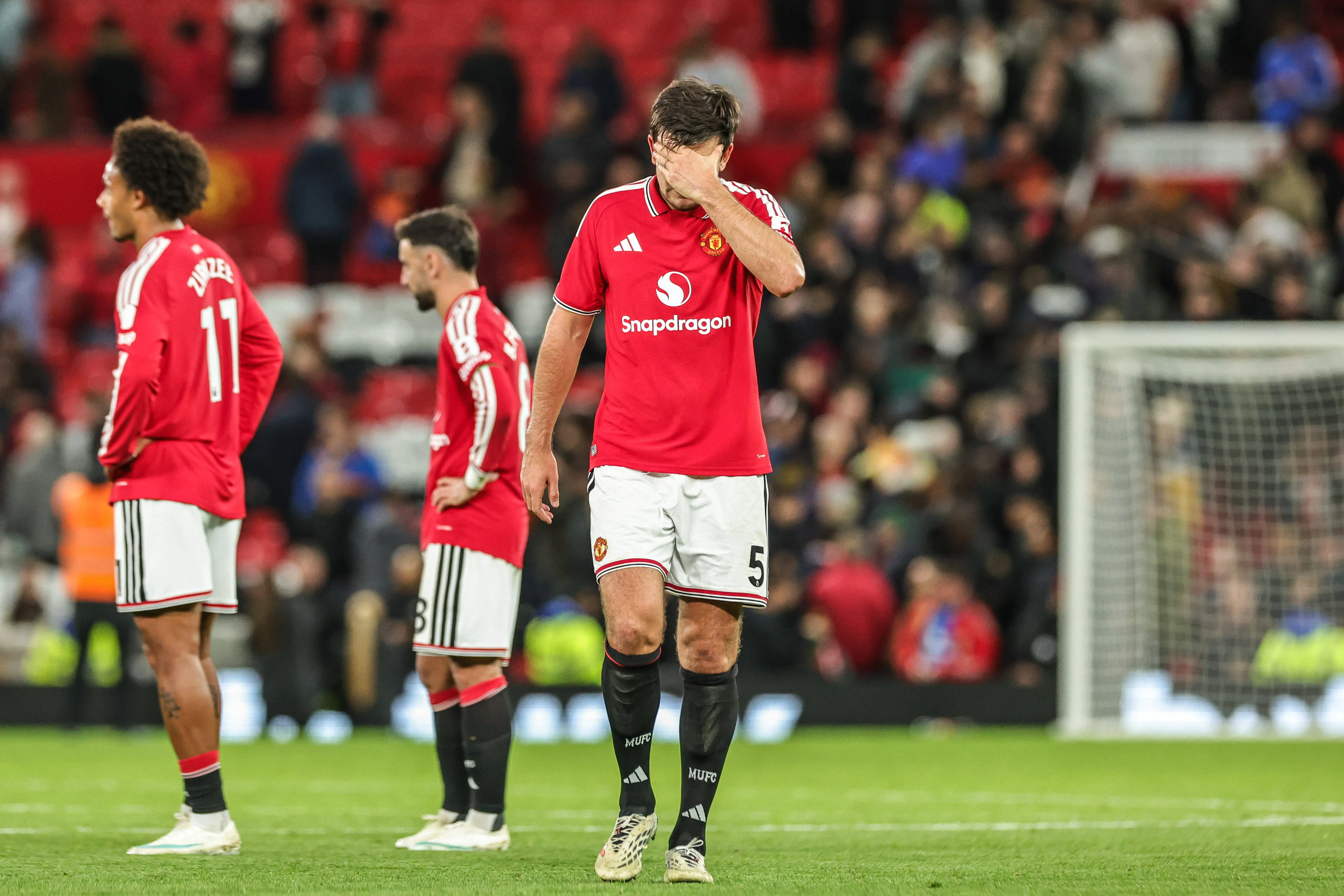 Jogadores do United cabisbaixos no gramado de Old Trafford
