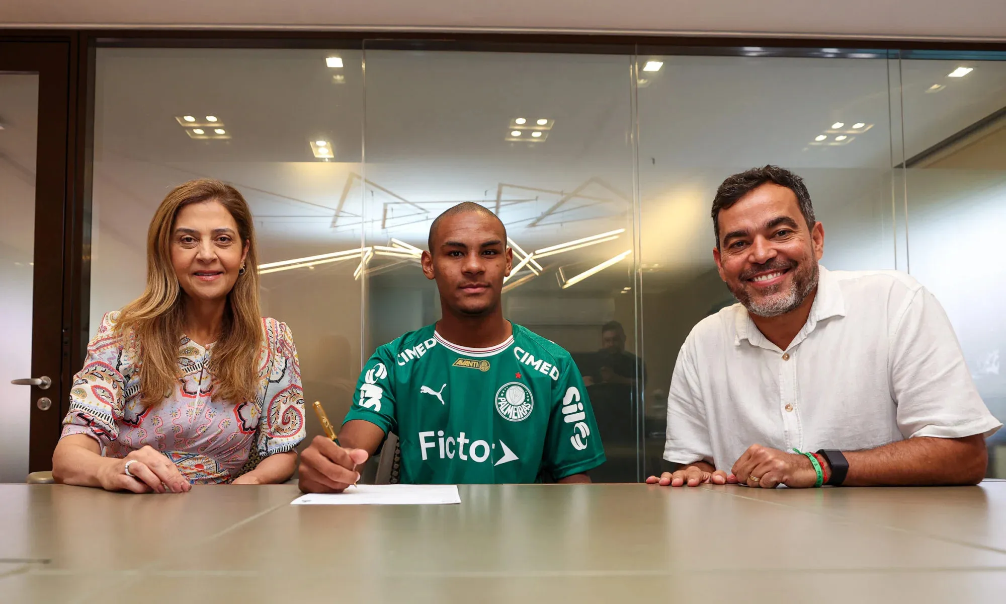 Eduardo Concei&ccedil;&atilde;o ao lado da presidente do Palmeiras, Leila Pereira, e o coordenador da base, Jo&atilde;o Paulo Sampaio, ap&oacute;s assinar primeiro contrato profissional com o clube