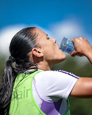 Jogadora do Cruzeiro feminino bebendo &aacute;gua durante treinamento