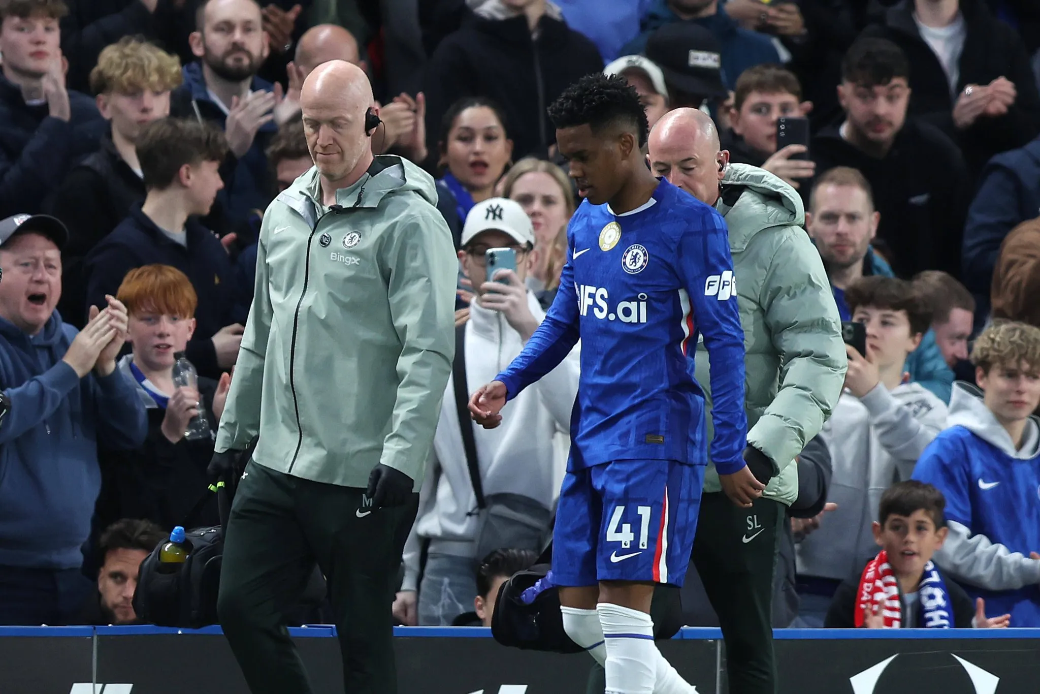 Est&ecirc;v&atilde;o deixa o campo acompanhado pelos m&eacute;dicos do Chelsea