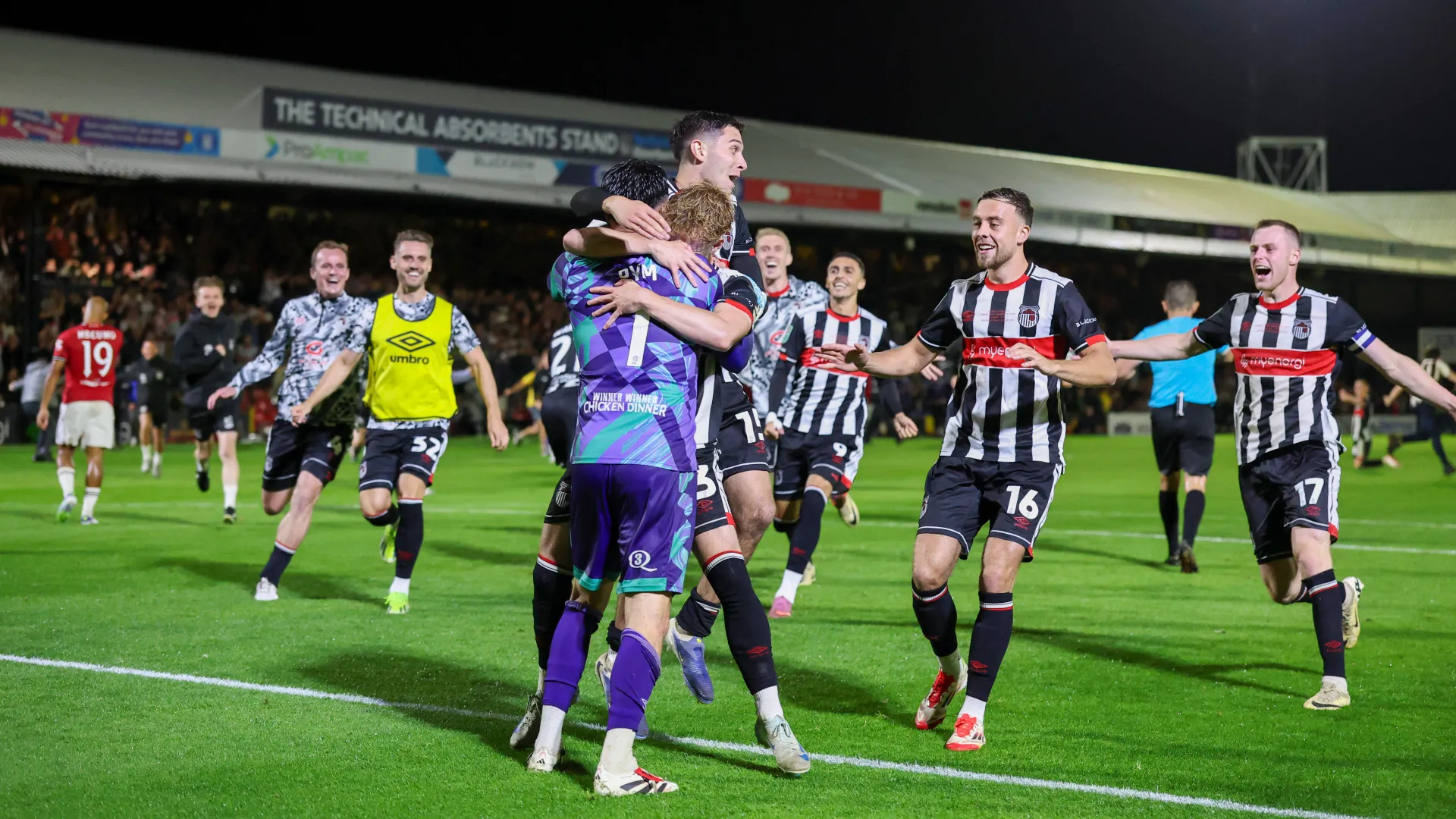 Jogadores do Grimsby Town, incluindo o goleiro Christy Pym, os zagueiros Reece Staunton e Cameron McJannet, o atacante Jaze Kabia e o meia Geza David Turi, celebram a vit&oacute;ria nos p&ecirc;naltis sobre o Manchester United na segunda rodada da Copa da Liga, em Blundell Park, em Cleethorpes, na Inglaterra, em 27 de agosto de 2025.