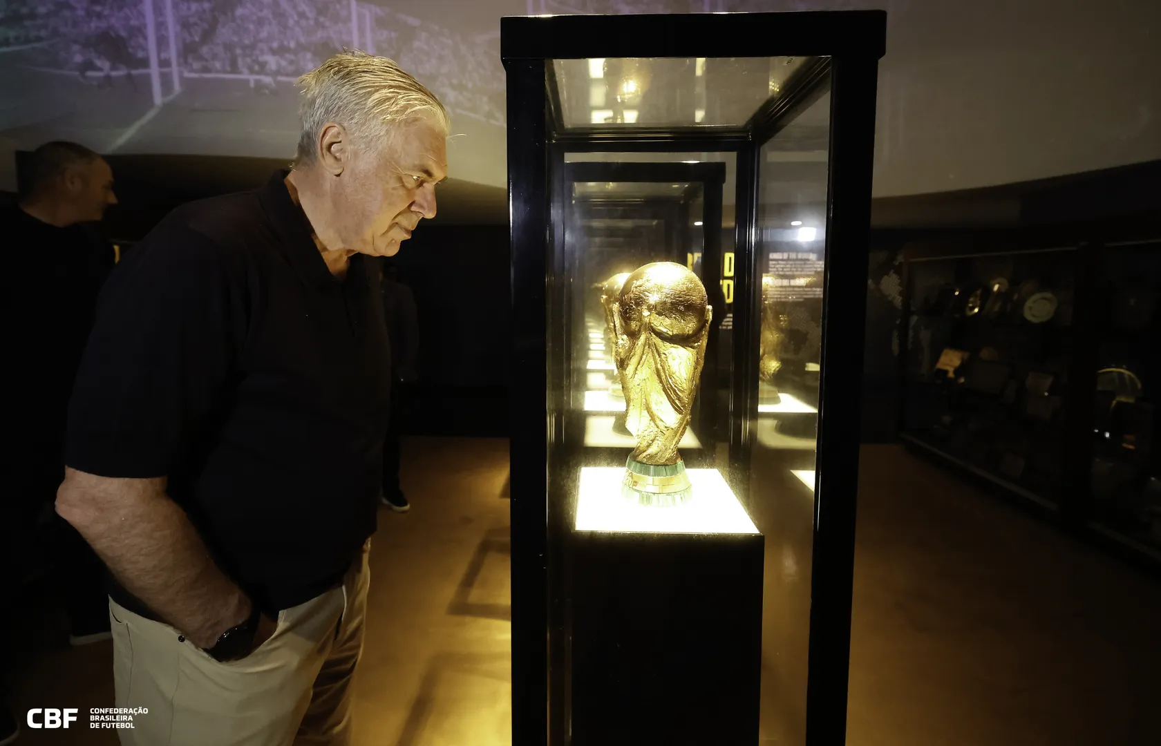 O novo t&eacute;cnico da sele&ccedil;&atilde;o Brasileira, Carlo Ancelotti, olha ta&ccedil;a da Copa do Mundo na sede da CBF