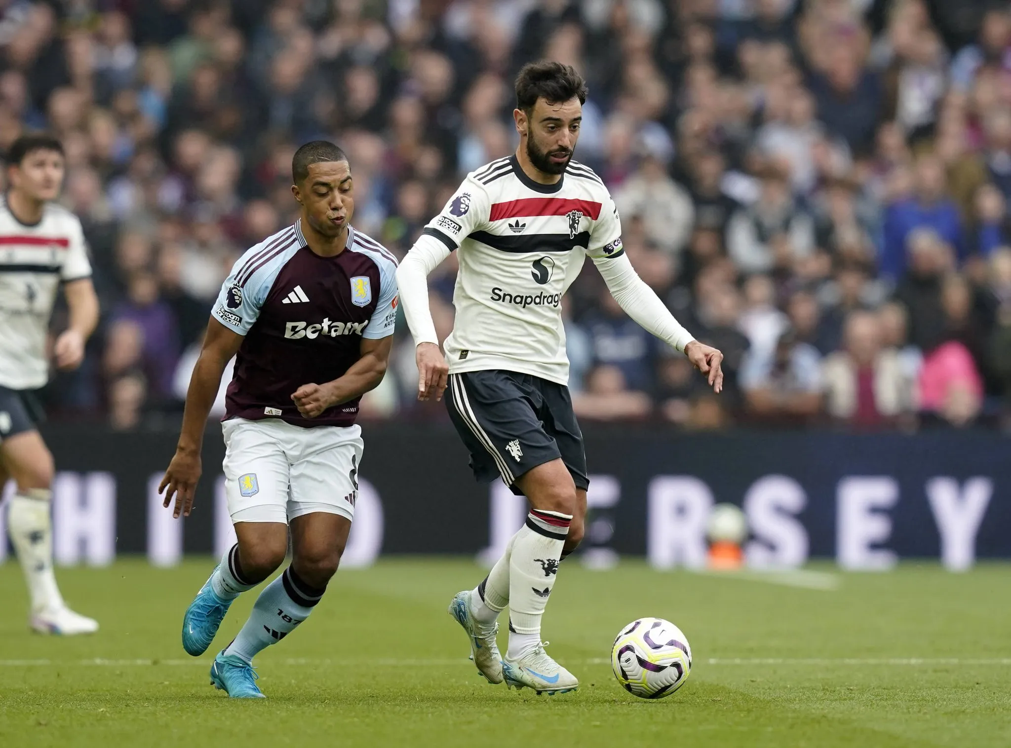 Tielemans e Bruno Fernandes em jogo entre Aston Villa e Manchester United em 2024