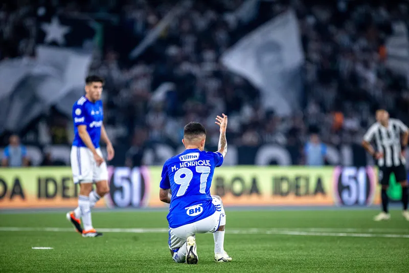 Matheus Henrique ajoelhado no gramado durante a partida entre Cruzeiro e Botafogo