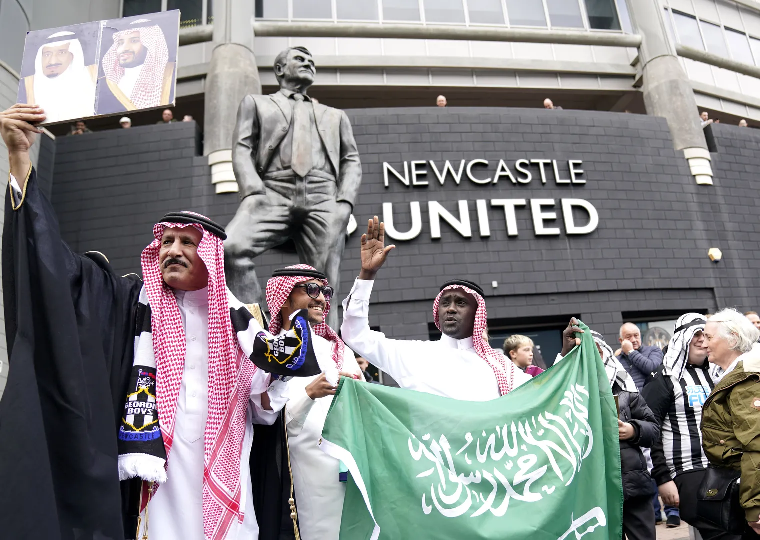 Torcedores do Newcastle se vestem com roupas tradicionais da Ar&aacute;bia Saudita e exibem bandeira do pa&iacute;s ap&oacute;s a aquisi&ccedil;&atilde;o do clube, em 2021