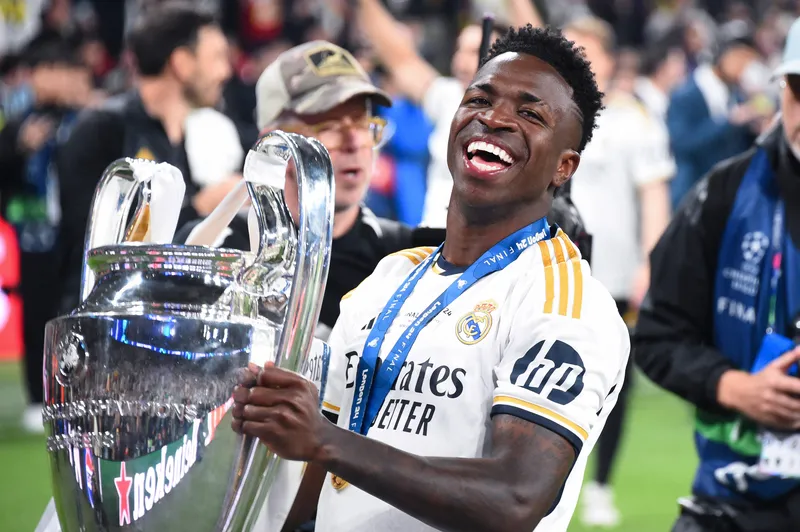 Vinicius J&uacute;nior posa com o trof&eacute;u da Champions League 