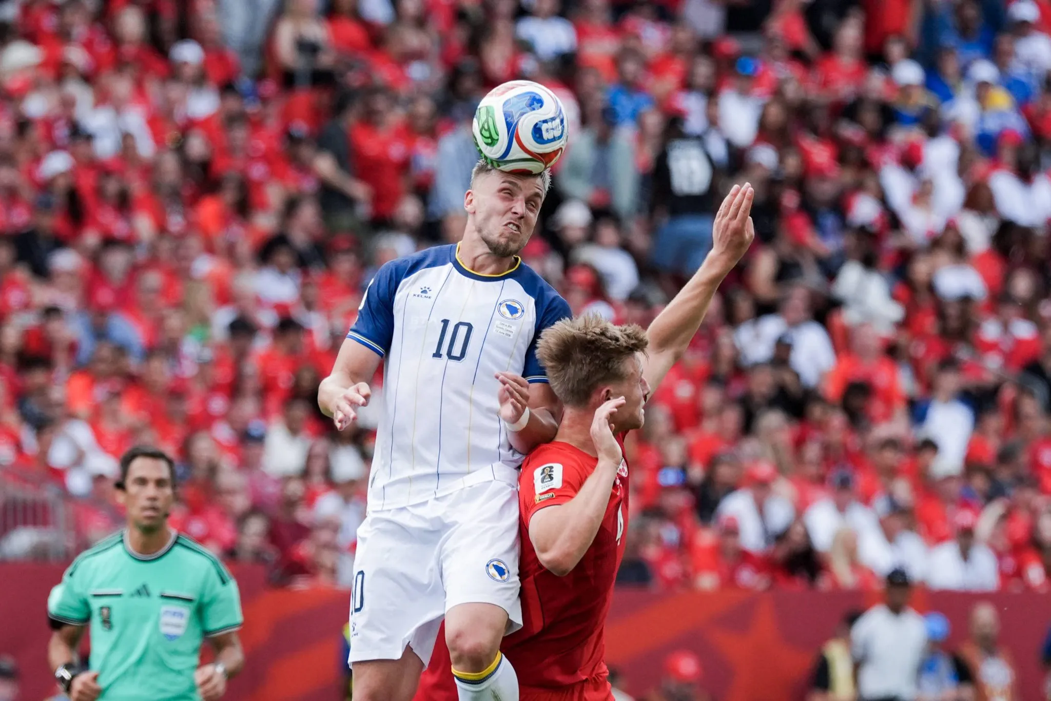 Ermedin Demirovic disputa bola pelo alto em Canad&aacute; x B&oacute;snia